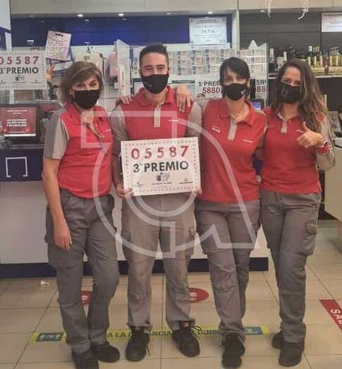 Empleados de la Estación de Servicios muestra el cartel con el premio vendido/TA.